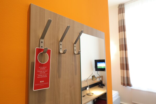 A wooden wall with three hooks and a sign that reads "Please do not disturb." - Townhouse Düsseldorf (Düsseldorf)