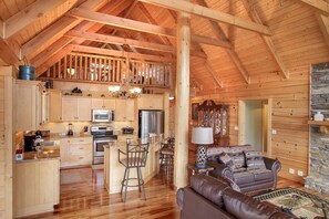 Ein geräumiges Blockhaus-Interieur mit Küche, Essbereich und Wohnzimmer.