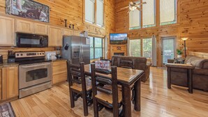 Una cabaña de troncos espaciosa con cocina, comedor y sala de estar.