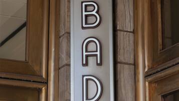 A wall-mounted sign with the letters 'BAD' and a downward arrow, indicating a direction or location.