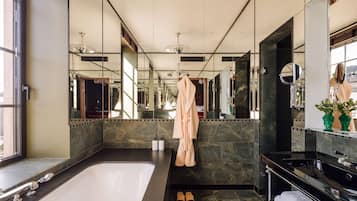 Un baño moderno con una bañera grande, un lavabo negro y un espejo.