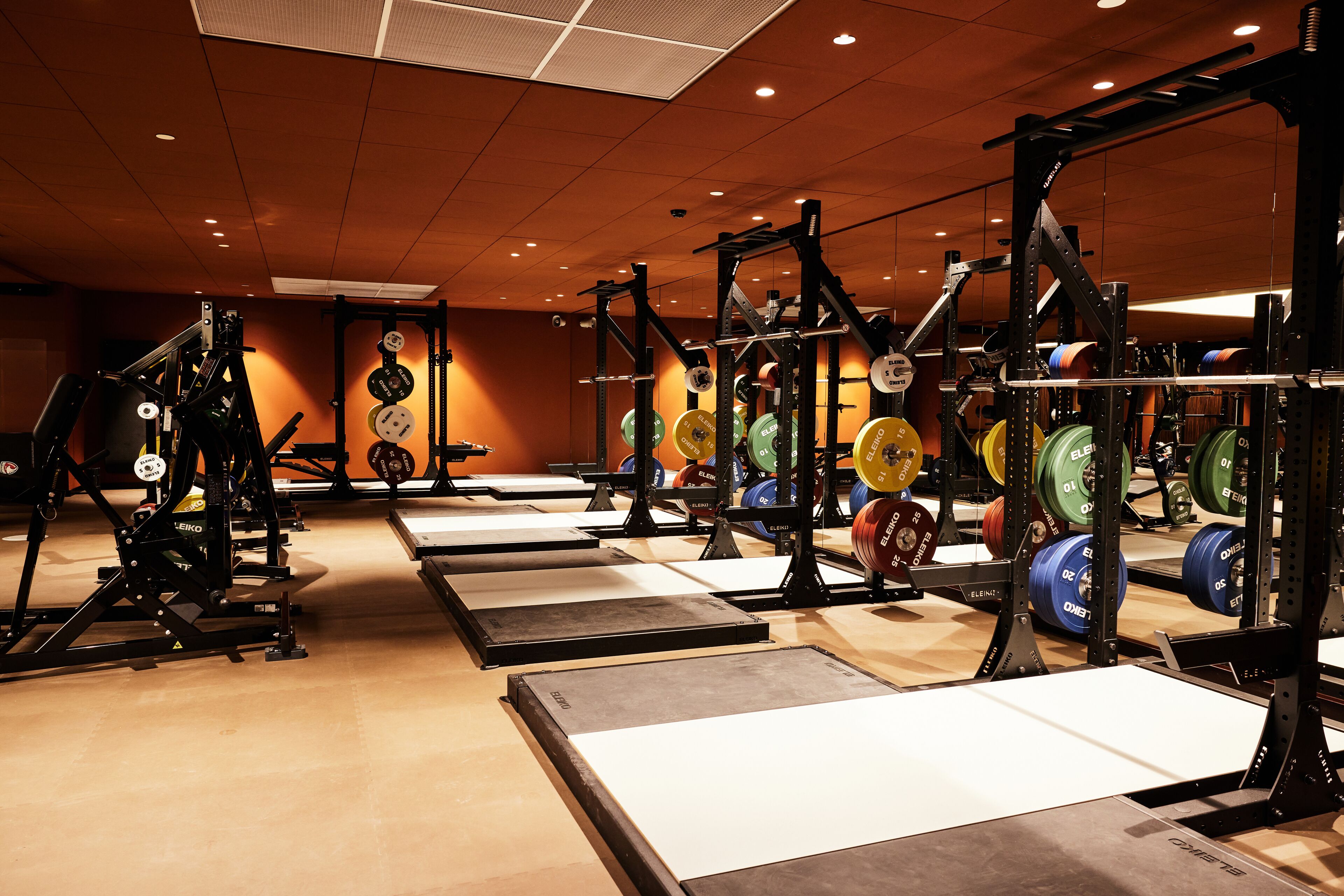 Un gimnasio con equipo de levantamiento de pesas y discos.