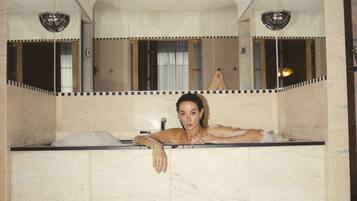 Une salle de bain avec une baignoire, un miroir et un lavabo.