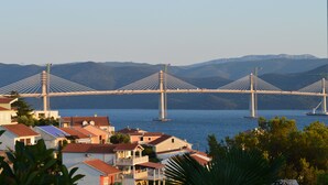 Un gran puente colgante cruza un cuerpo de agua, con edificios residenciales al frente.