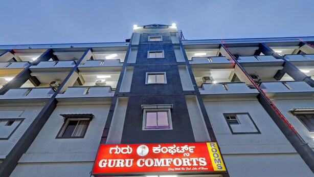 A multi-story building with a sign for "Guru Comforts" indicating rooms available. - Guru Comfort, 100 m from Apollo Hospital (Bengaluru)