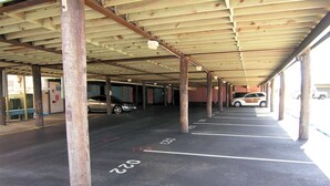 A covered parking area with multiple rows of parking spaces, marked with white lines and numbers.