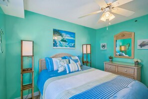 A bedroom with a bed, a ceiling fan, a painting, a mirror, and a dresser. - XPLORIE ACTIVITIES & LINENS INCLUDED*!  2BR/2BA Capri condo with ocean & bay views! (Ocean City)
