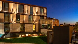 Un hôtel moderne à plusieurs étages, doté de balcons, d’une piscine et d’une pelouse bien entretenue.