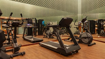 Un gimnasio con cintas de correr y equipo de ejercicio.