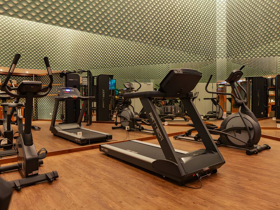 Un gimnasio con cintas de correr y equipo de ejercicio.