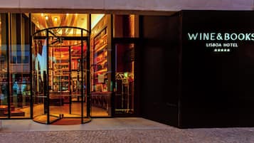 Entrada de hotel com porta giratória e placa com a inscrição 'WINE&BOOKS LISBOA HOTEL'.