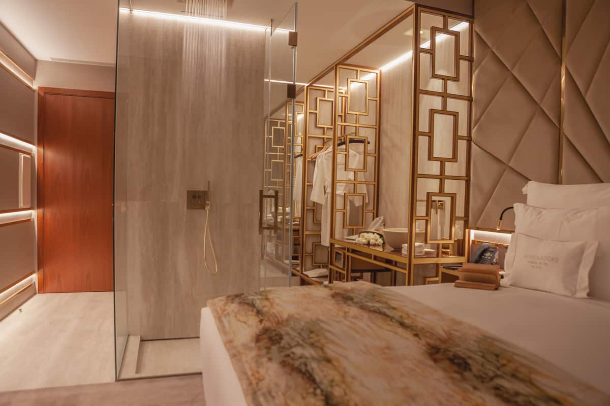 Une chambre d’hôtel moderne dotée d’un grand lit, d’un bureau et d’un dressing.