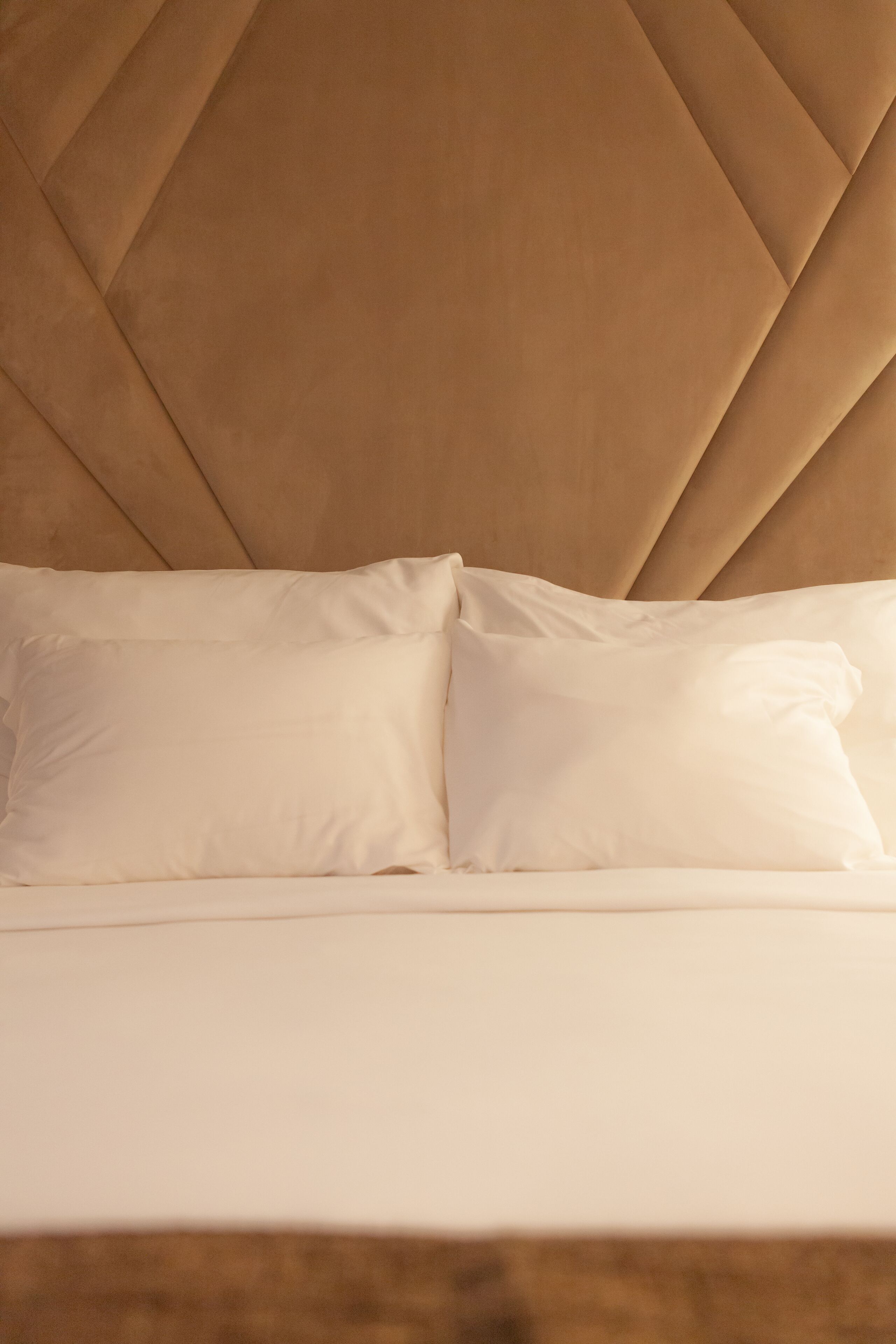 A bed with a tufted headboard and two pillows.