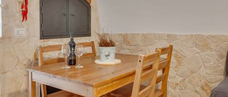 A dining table with chairs, a wine bottle, and glasses.
