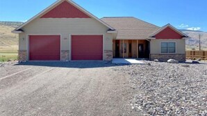 A two-story building with a garage and a small attached structure. - Windsor Drive Monthly Rental (Cody)