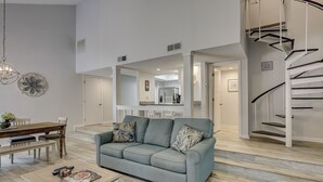A spacious living room with a sofa, coffee table, and a dining area. - Sunset Rentals | St. Andrews 1662 (Hilton Head Island)