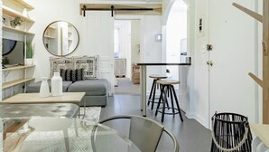 A modern living room with a glass table, grey sofa, and black and white patterned wall art. - Dupont Circle sub station DC Apart High speed WiFi (Washington)