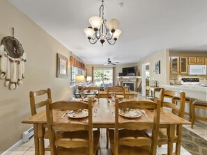 A dining area with a chandelier, wooden chairs, and a table set for four. - Swans Nest Villa 1304 2 Bedroom Condo by RedAwning (Breckenridge)