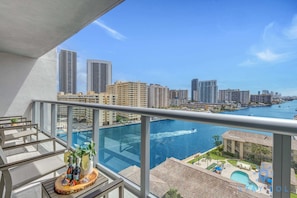 A balcony with a view of a city skyline and a marina.