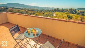A balcony with a table set for breakfast, overlooking a vineyard and distant hills. - Villa AZALEA by Abahana Villas (Teulada)