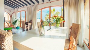 Un comedor amplio con techos altos, ventanas grandes y vistas a la ciudad.