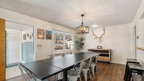 A conference room with a long table, several chairs, a plant, and a deer antler decoration. - Blue Roof Lodge: Pet-Friendly, Walkable to Downtown Custer (Custer)