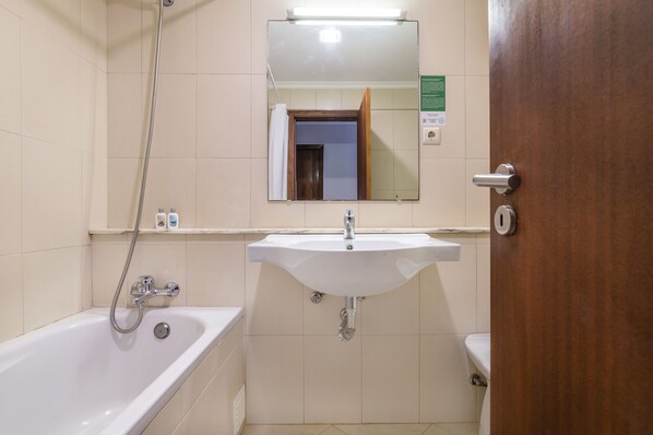 A bathroom with a bathtub, sink, and toilet.