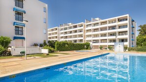 Ein modernes Hotel mit Schwimmbad, mehreren Balkonen und einem gepflegten Garten.
