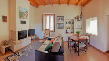 Apartamento básico, 2 quartos | Área de estar | TV de tela plana 50 cm com canais a cabo, TV, lareira