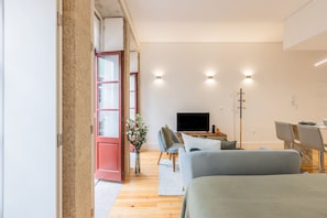 Una sala de estar moderna con sofá, televisor y comedor.