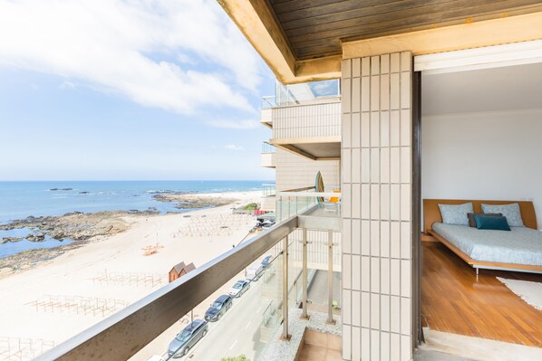 A balcony with a view of the beach and ocean.