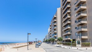 A beachfront hotel with multiple floors, balconies, and a clear view of the beach. - Povoa Sunset Views (Povoa De Varzim)