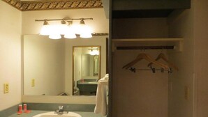 A bathroom with a sink, mirror, and towel rack. - Econo Lodge Expo Center (Portland)