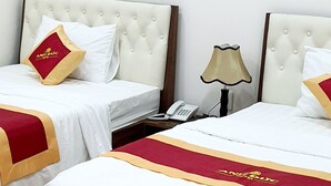 A hotel room with two beds, a TV mounted on the wall, and a telephone on the nightstand. - HANZ Anh Duc Hotel Binh Duong (Ho Chi Minh City)