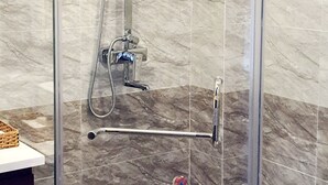 A glass-enclosed shower with a handheld showerhead and a wall-mounted faucet. - HANZ Anh Duc Hotel Binh Duong (Ho Chi Minh City)