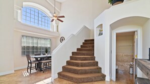 Ein geräumiger Wohnbereich mit Treppe, Esstisch und Blick ins Freie.