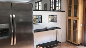A kitchen with a stainless steel refrigerator, a black countertop, and a wooden cabinet. - Topanga Deck House light spacious, amazing mountain views, huge deck under Oaks (Topanga)