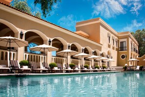 A poolside area with lounge chairs and umbrellas, a clear blue sky, and a building with arches and a tiled roof. - Villa Antigua (Tequisquiapan)