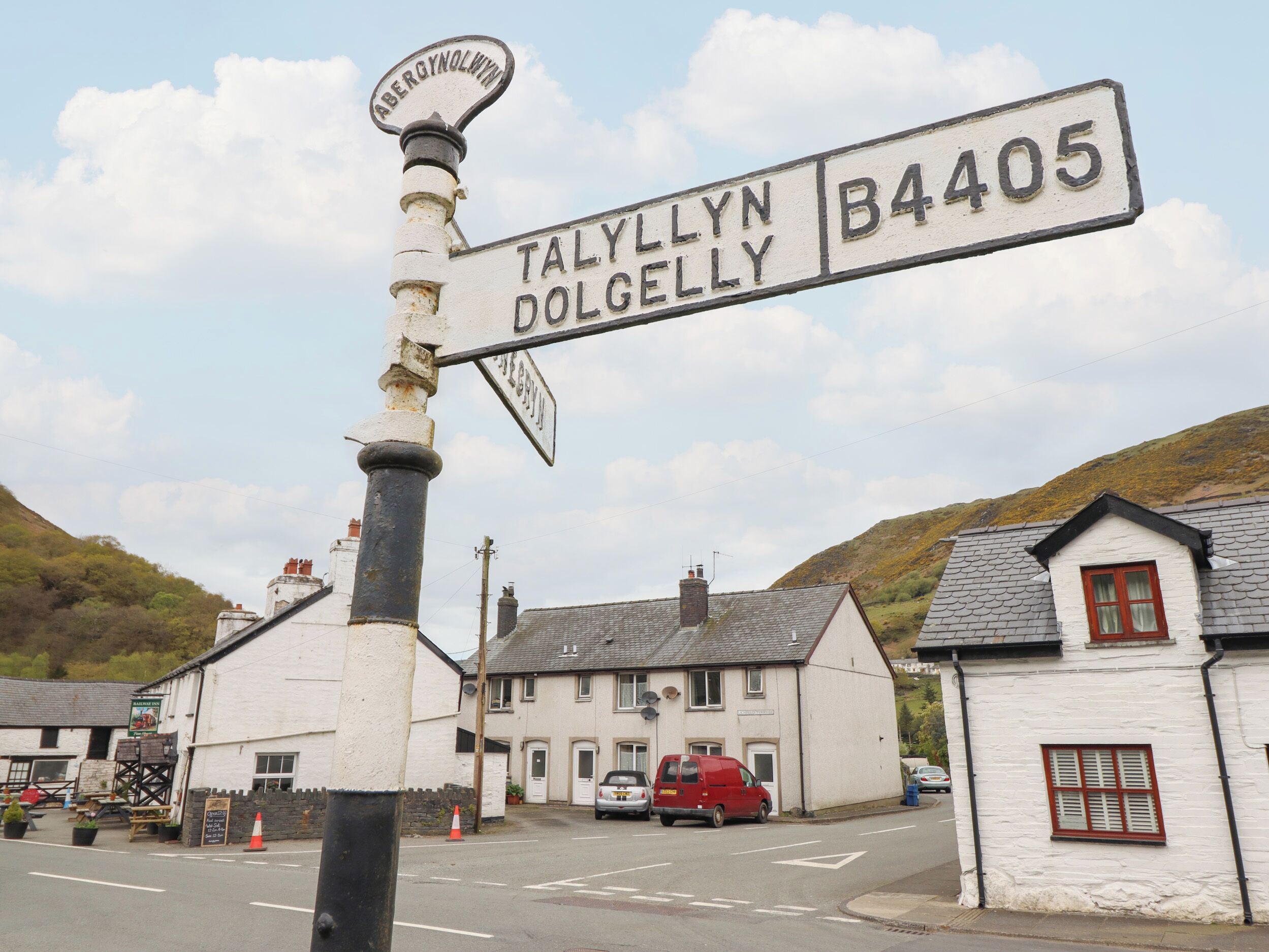 Un cartel direccional con 'TALYLLYN DOLGELLY' y 'B4405' que indica una ruta.