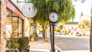 A street view with a wine and cheese shop, a clock, and potted plants along the sidewalk. - Experience the perfection of Half Moon Bay Oasis By Pillar Point Beach! (El granada)