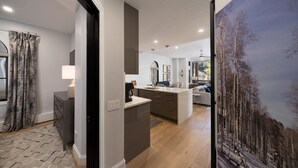 Een moderne keuken met een centraal eiland, een eetgedeelte met uitzicht en een woonruimte met een groot raam.