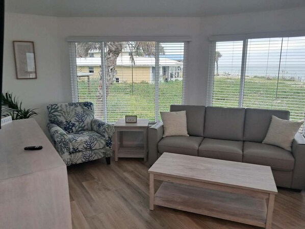 A living room with a sofa, armchair, coffee table, and a small side table.