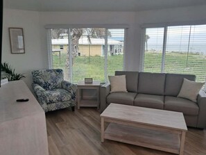 A living room with a sofa, armchair, coffee table, and a small side table.