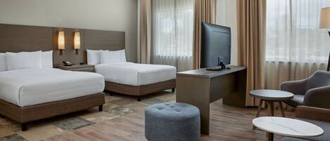 Een hotelkamer met twee bedden, een televisie, een bureau en een zithoek.