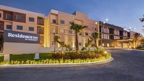 Entrada d'un hotel amb un cartell que diu "Residence Inn by Marriott" i un carrer d'accés ben il·luminat.
