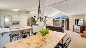 A spacious kitchen with a dining area, a large window, and a TV. - Calistoga Vineyard Getaway - Hot Tub and Tastings Included (Calistoga)