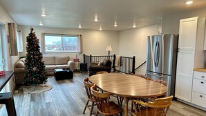 A modern kitchen with a dining area, a Christmas tree, and a cozy living room.