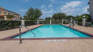 Une piscine rectangulaire dotée d’un plongeoir et d’un panneau indiquant une profondeur minimale de 3 pieds pour la plongée.