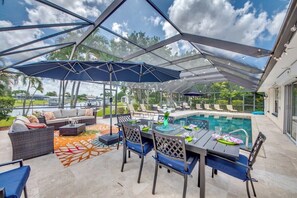 Eine Terrassengaststätte mit Pool, überdachter Sitzgelegenheit und Essbereich.