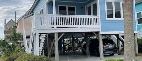 A two-story house with a balcony, a covered porch, and a garage.